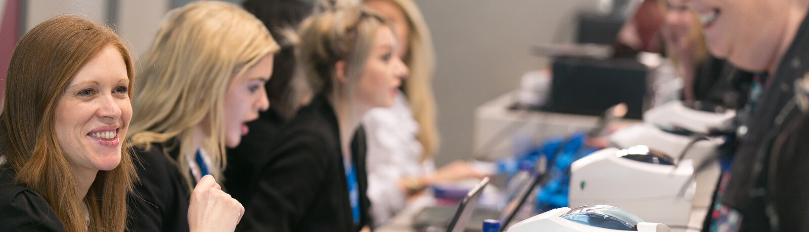 Registration staff supporting on-site check-in alongside badge printers at an event desk