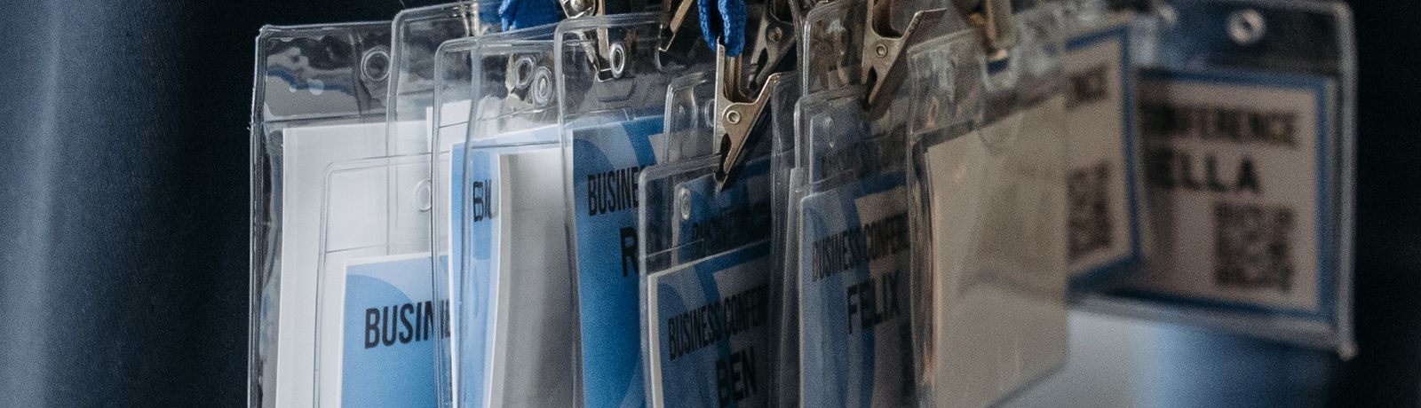 Printed business conference badges with barcodes and QR codes, hanging on blue lanyards