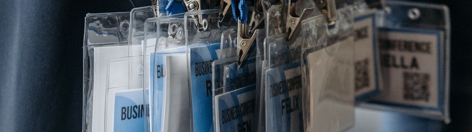 Conference badge holders on lanyards ready for issue at an accreditation desk
