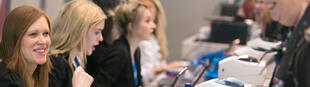 Event registration staff checking in delegates at a desk with badge printers