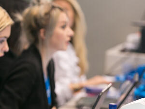 Registration staff supporting on-site check-in alongside badge printers at an event desk