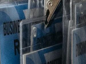 Printed business conference badges with barcodes and QR codes, hanging on blue lanyards