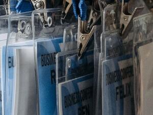 Conference badge holders on lanyards ready for issue at an accreditation desk