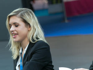 Event staff greeting delegates wearing lanyards on a conference floor