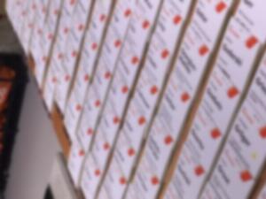 Rows of pre-printed event name badges laid out ready for collection at registration